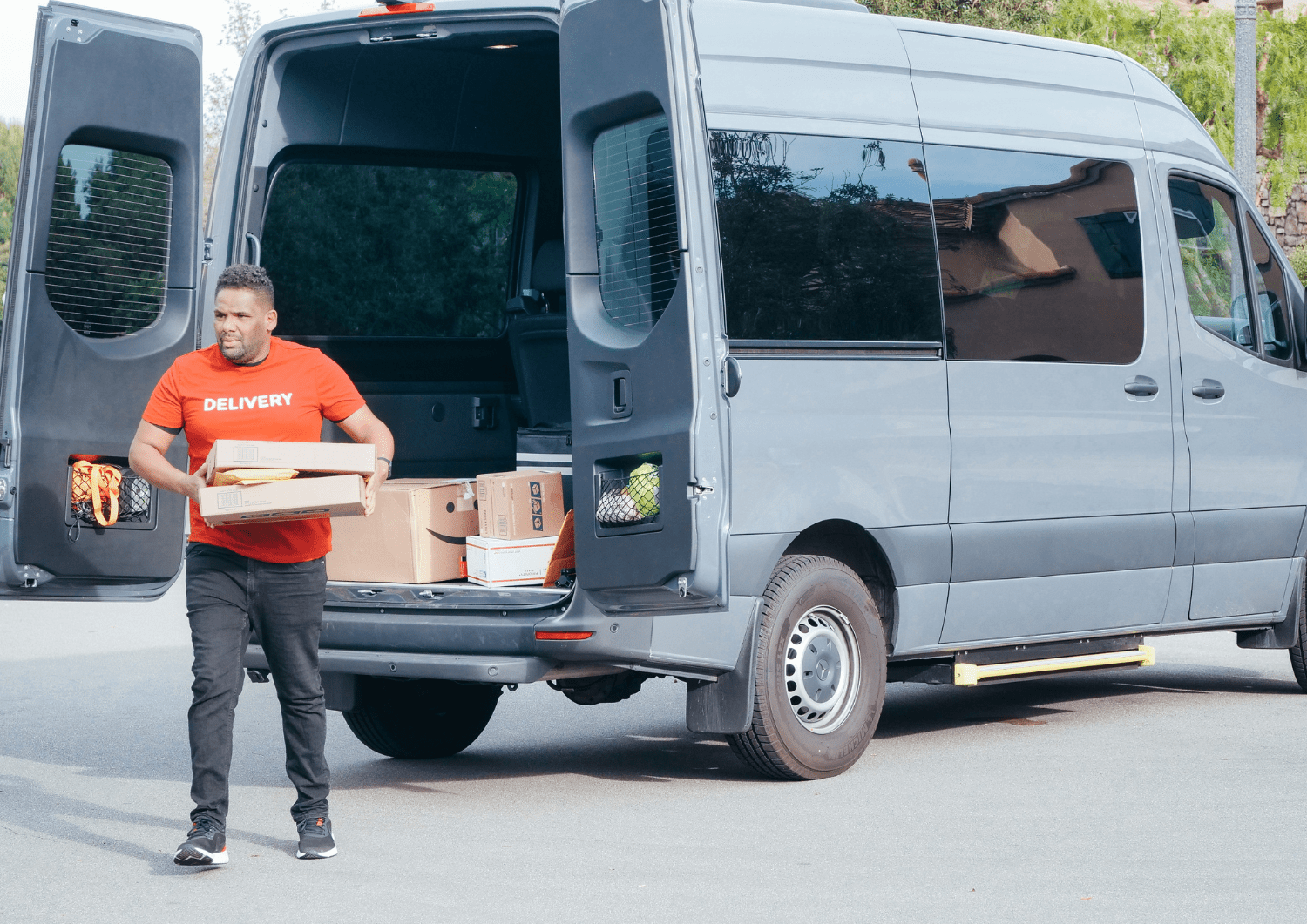 Hombre saliendo de su furgoneta para realizar la entrega de un pedido online